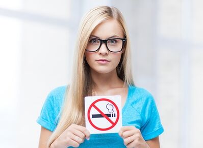 fille tenant un panneau d'interdiction de fumer à l'entrée